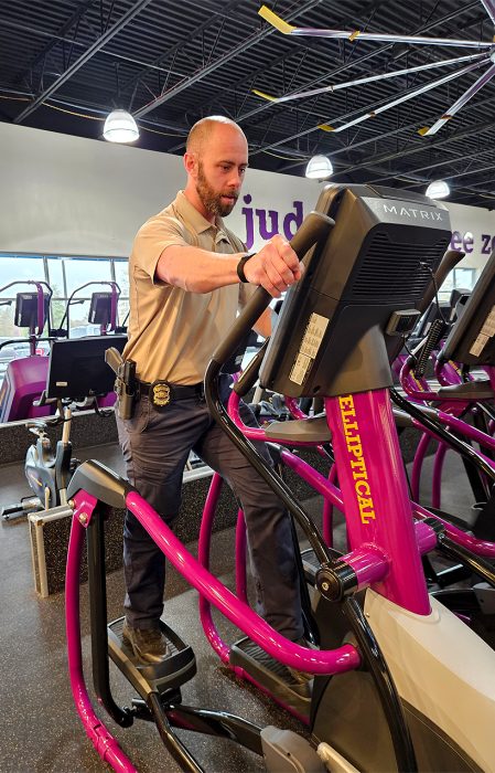 A police officer exercises on donated cardio equipment.