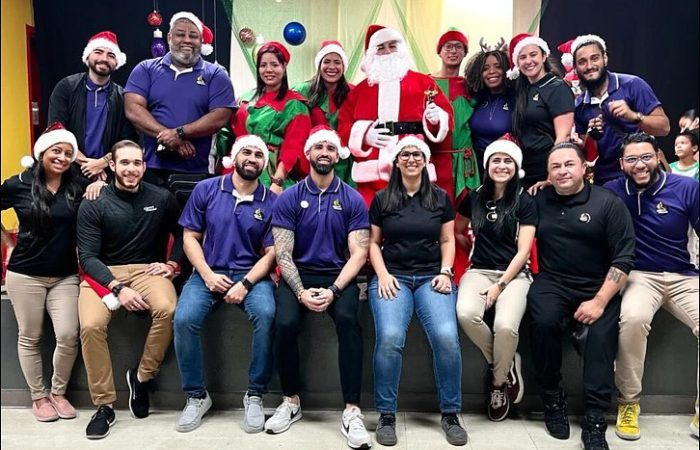A group of Easy Mile Fitness staff members wear holiday apparel.