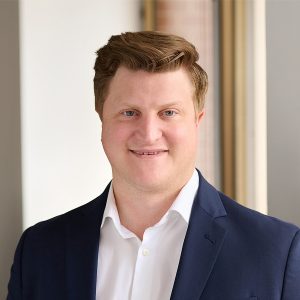 A member of the Easy Mile Fitness leadership team smiles at the camera in a professional headshot.