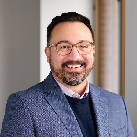 A member of the Easy Mile Fitness leadership team smiles at the camera in a professional headshot.