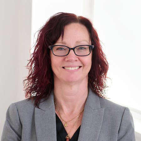A member of the Easy Mile Fitness leadership team smiles at the camera in a professional headshot.