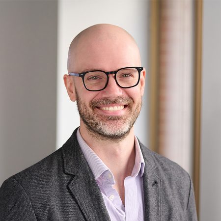 A member of the Easy Mile Fitness leadership team smiles at the camera in a professional headshot.