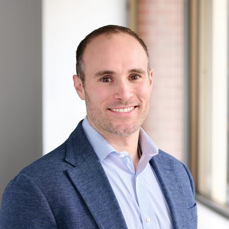 A member of the Easy Mile Fitness leadership team smiles at the camera in a professional headshot.