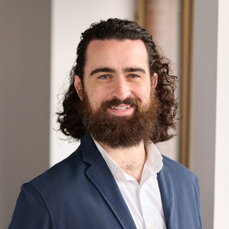 A member of the Easy Mile Fitness leadership team smiles at the camera in a professional headshot.